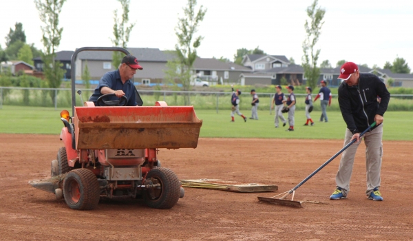 Murray Dalrymple (left) and Chad Reimer work on Lions Diamond #1 to get it ready for Provincials in 2016. A donation from the Dalrymple family of $100,000 was given last year to help with maintenance at the diamonds. This year, they are doing work on diamond #1 and building a shed. They also have an eye on further improvements to the entire area. 