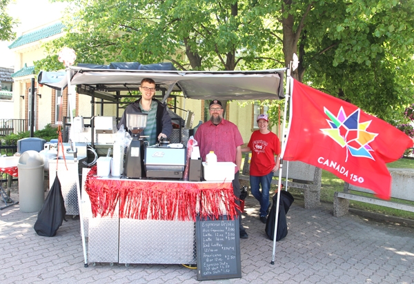 Dan Meaud (middle) is opening a new coffee and pizza shop in 2018 in the old Ag Office building (in background of photo). Dan and his wife Tricia, along with friend Jelle Geurts, sold specialty coffees on Canada Day.