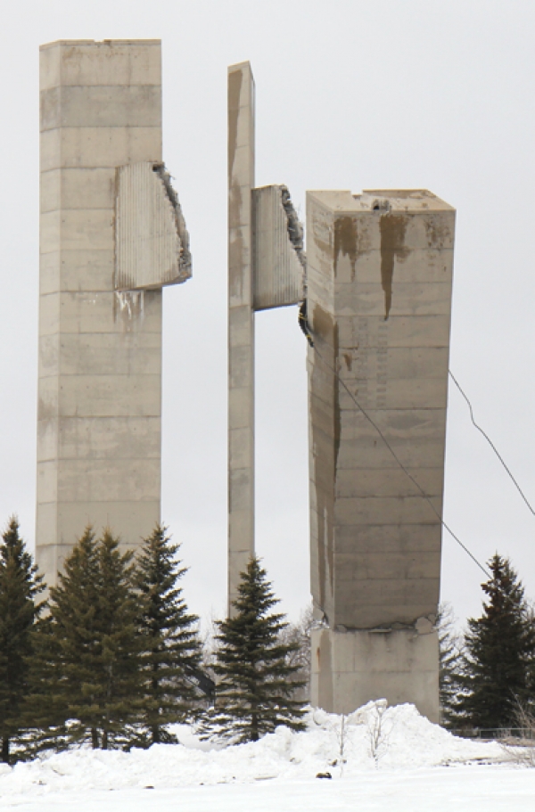 On Thursday, March 16 the first tower was pulled down by chains and a tow truck. By mid-afternoon  on Friday, the second tower was on it’s way to the ground. What was originally supposed to take seven days has now taken four weeks and work is not yet complete. The bottoms of the four towers are still in place, waiting to be removed. The crew has until the end of the month to complete the work.