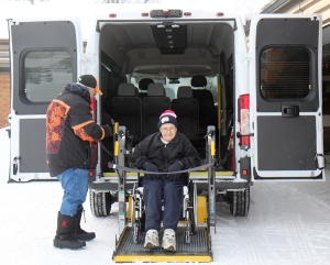 Driver Ken Dixon loads Vic Rayner into the new Handi-Van.
