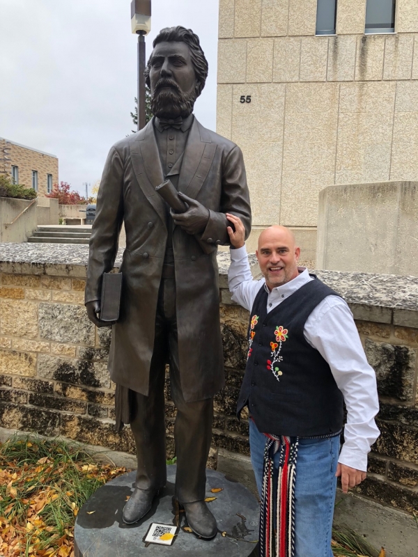 Will Goodon, Southwest Region Director for the Manitoba Metis Federation stands next to the Louis Riel statue at the University of Manitoba.