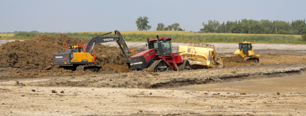 Equipment from Dougall Excavating digs into the earth at the site for the new lagoon southwest of Boissevain. After years of planning, the practical work, done by local subcontractors, is finally underway.	