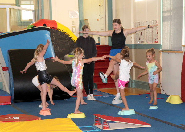 Alyssa Bos teaches the Little Weeds about beginner's positions on the balance beam.